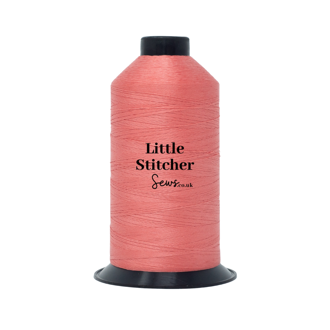 Spool of coral thread with 'Little Stitcher Sews' branding on a white background