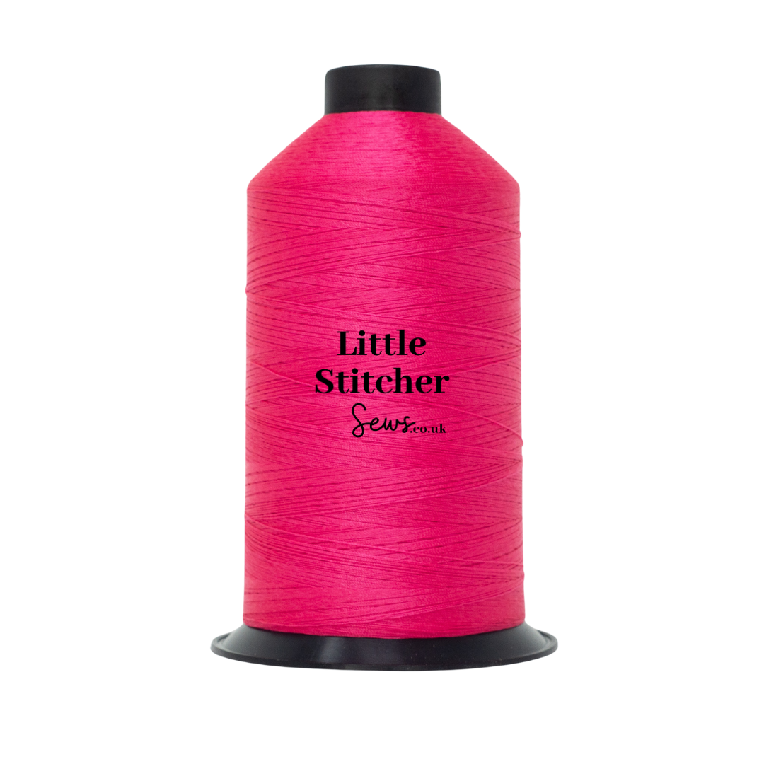 Spool of fuchsia pink thread with 'Little Stitcher Sews' branding on a white background