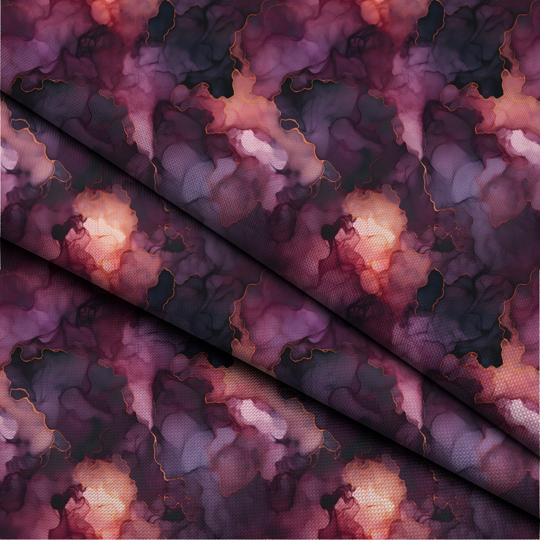 A close-up of draped fabric with an abstract marbled pattern in deep purple, burgundy, black, and peach tones with thin gold contour lines.