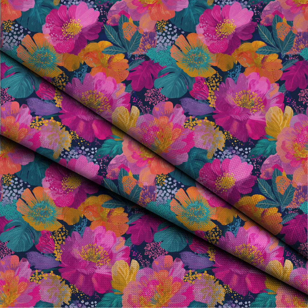 A close-up of a folded piece of fabric with a vibrant floral print. The pattern features large pink and orange flowers, teal leaves, and small white dots on a dark navy background.